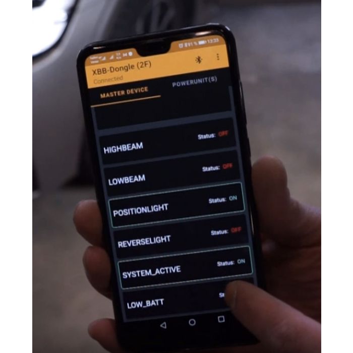 XBB dongle app med bilbelysningsindstillinger på mobiltelefon skærm med fingre