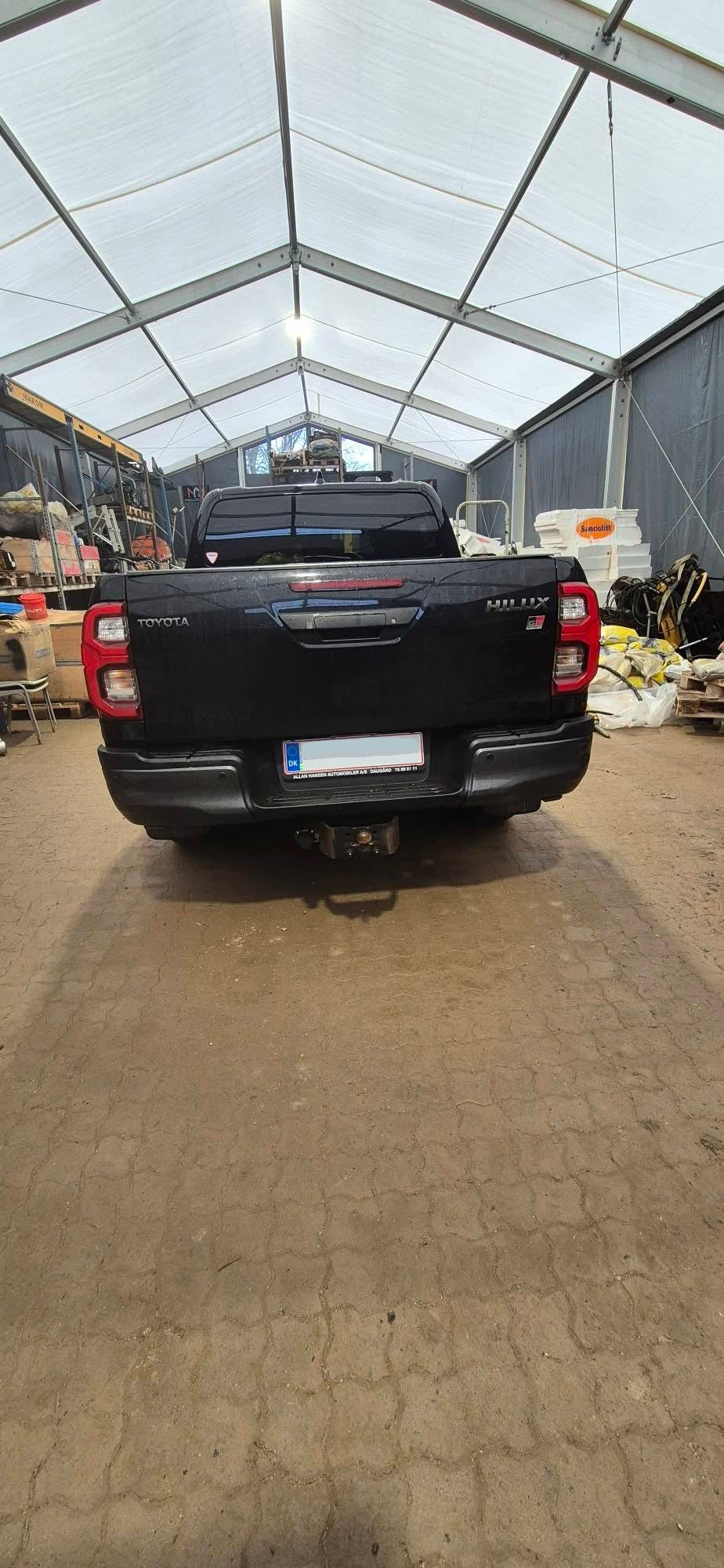 Sort Toyota Hilux lastbil set bagfra i telt med lagerartikler